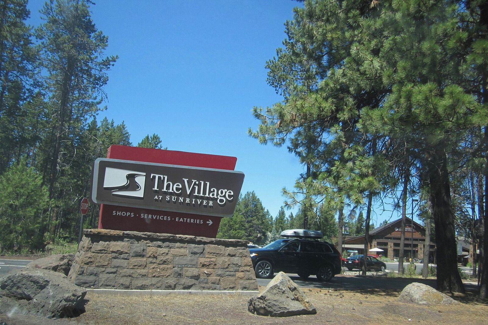 The Village at Sunriver entrance sign set in stone among pines